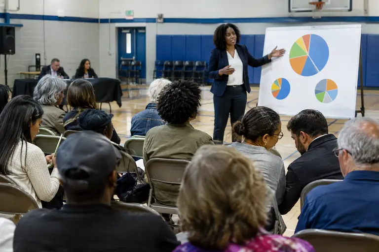 Resident comparing public meeting agenda pages and budget notes